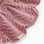 Knitted scarf in muted rose color with detailed pattern and Mølner brand.