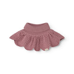 Knitted scarf in muted rose color with crinkled pattern and ribbed edge.