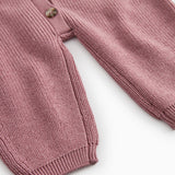 Dusty pink sweater dress with ribbed cuffs and button detail at the hem