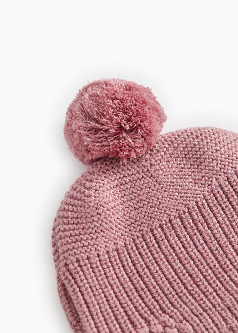 Pinkish-purple with a large pompom and a uniform knit pattern.