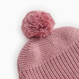 Pinkish-purple with a large pompom and a uniform knit pattern.