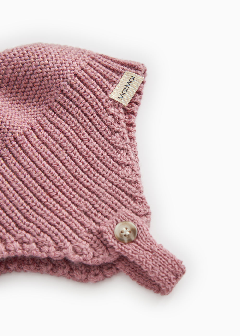 Details of striped pattern in pink-purple: rib stitch, label, and small button