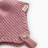 Details of striped pattern in pink-purple: rib stitch, label, and small button