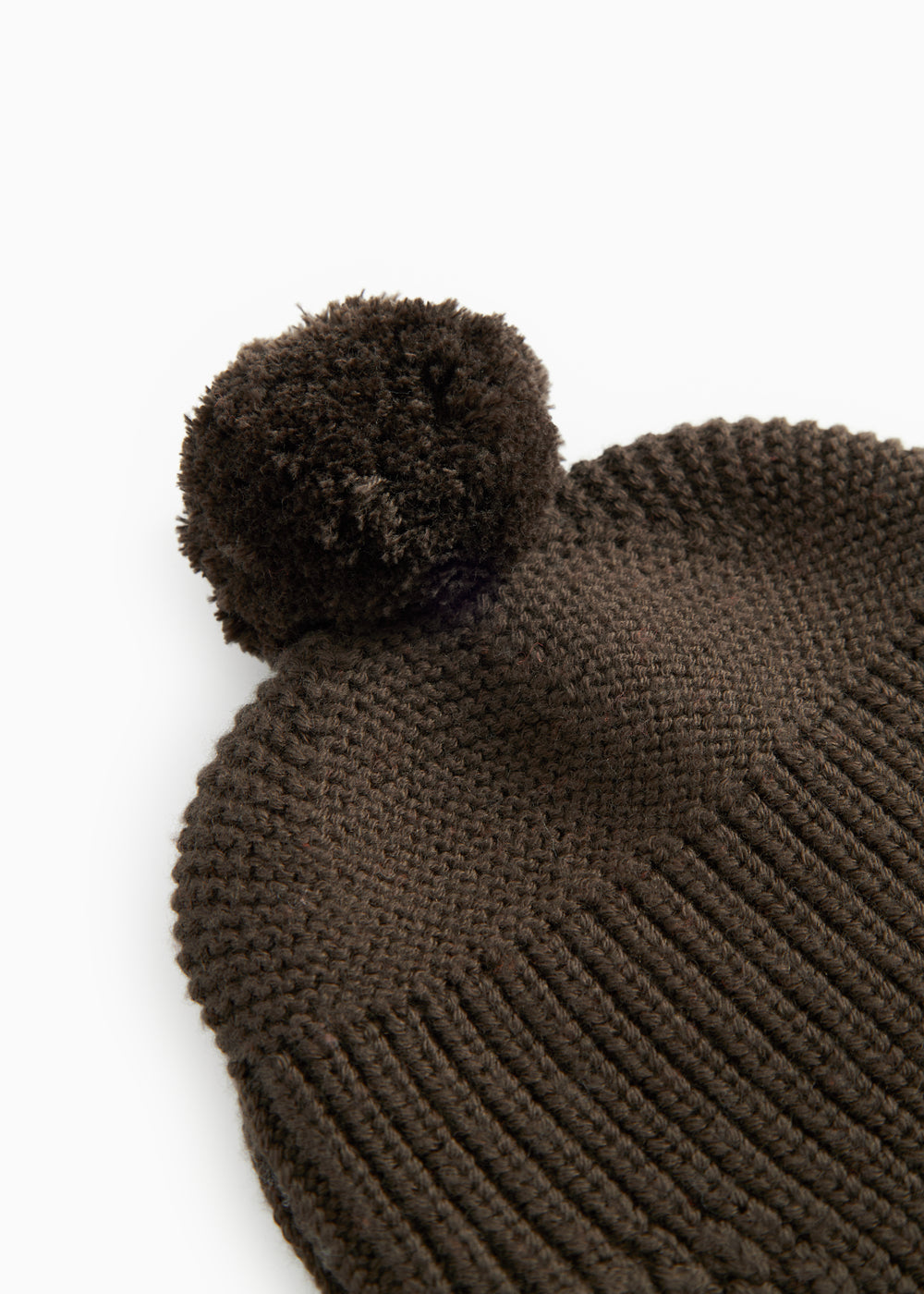 Dark brown knit cap with a large pom-pom and ribbed knit pattern.