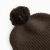 Dark brown knit cap with a large pom-pom and ribbed knit pattern.