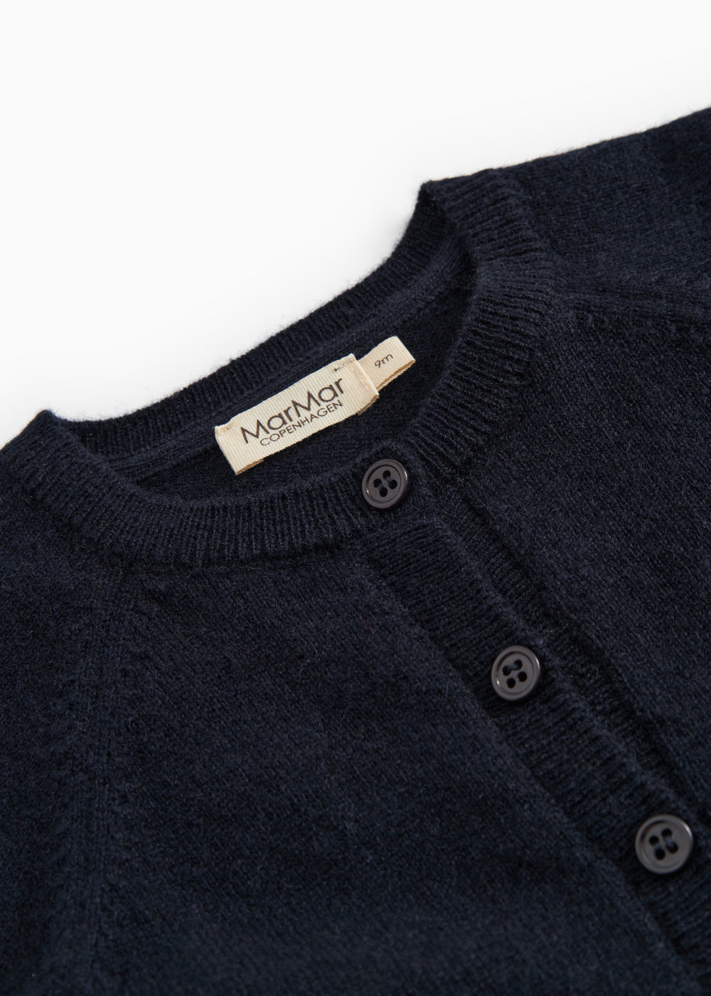 Dark indigo baby cardigan with ribbed edge, button closure, and branded neckline.
