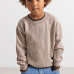 Gray knitted blouse with round collar and ribbed edges, worn with blue jeans.