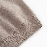 Gray textured knit sweater with ribbed cuffs.