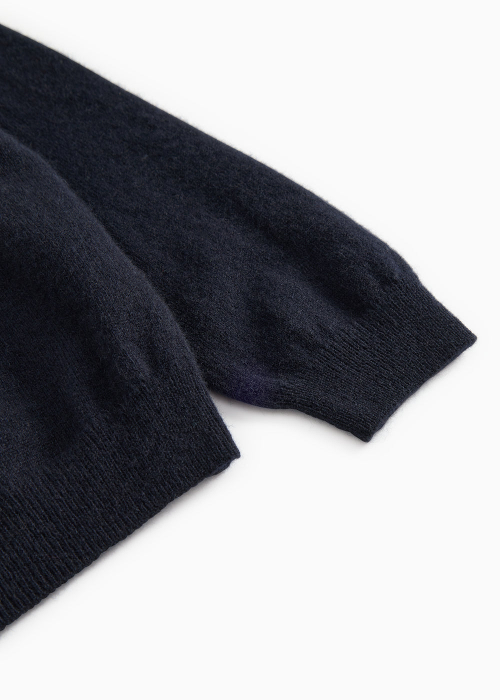 End of sleeve on dark indigo polo shirt with ribbed edge.
