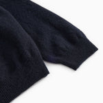 End of sleeve on dark indigo polo shirt with ribbed edge.