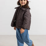 Dark insulated jacket with zipper and fine polka‑dot pattern surface