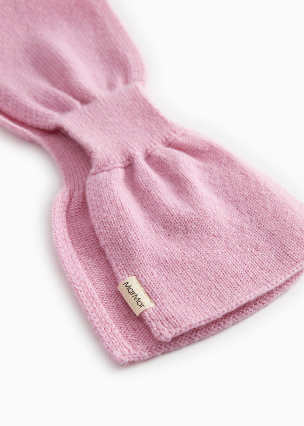 Pink knit baby blanket with label on the fold and rib edge.