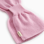 Pink knit baby blanket with label on the fold and rib edge.