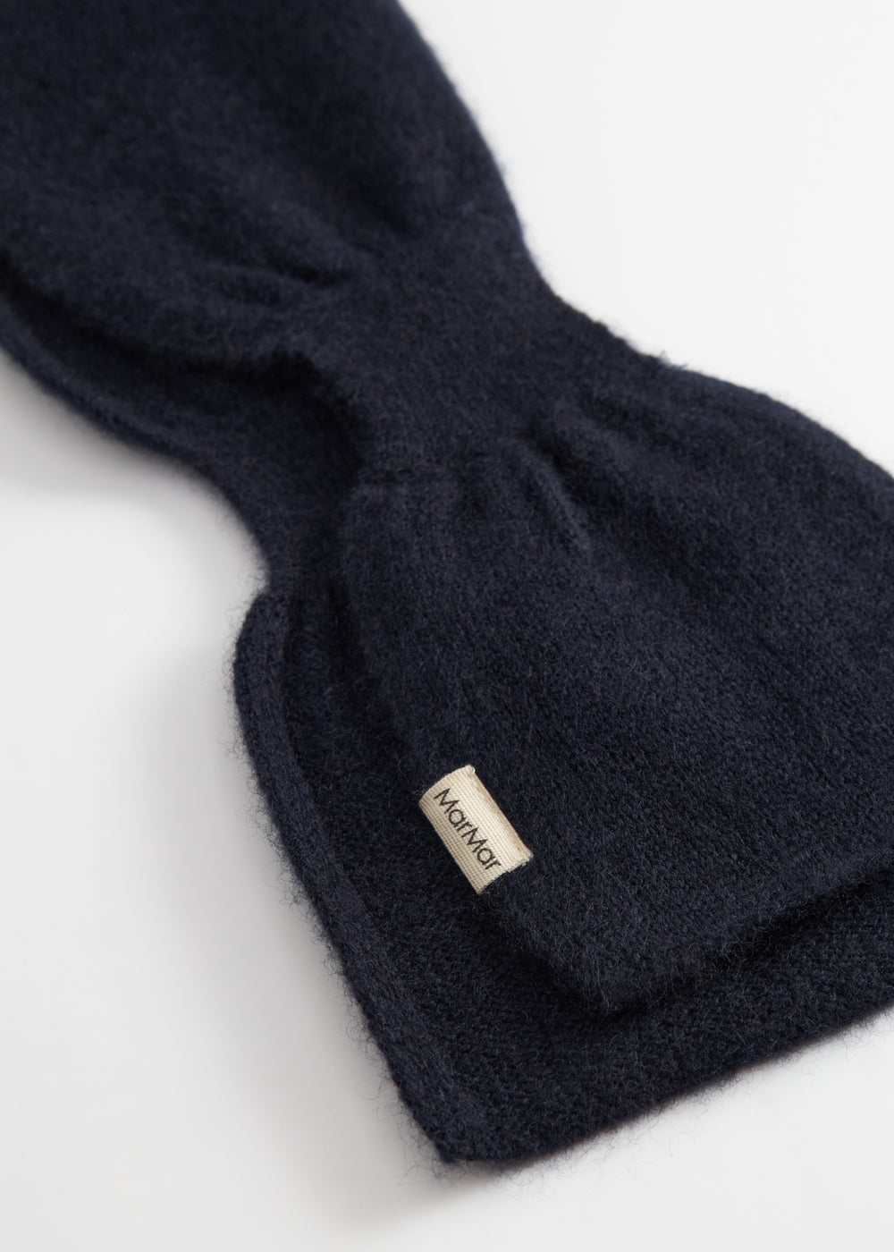 Dark indigo Kashmir scarf with stitching and logo tag at the end.