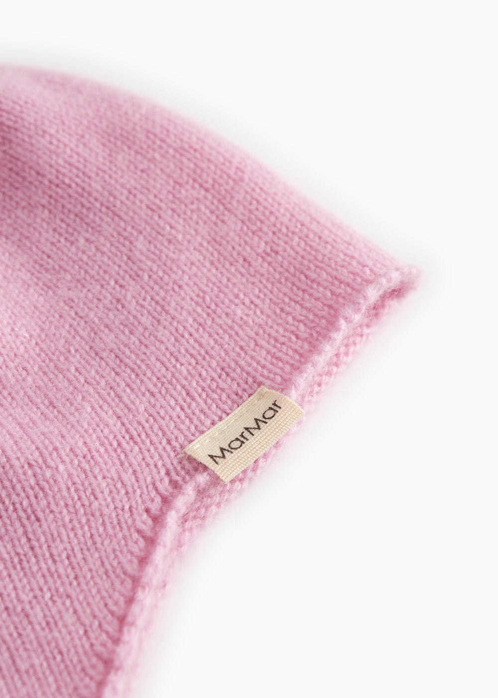 Pink baby hat in knit with a small tag at the edge