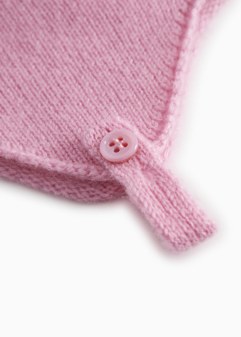 Pink baby hat in knit with button detail and drawstring.