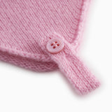 Pink baby hat in knit with button detail and drawstring.