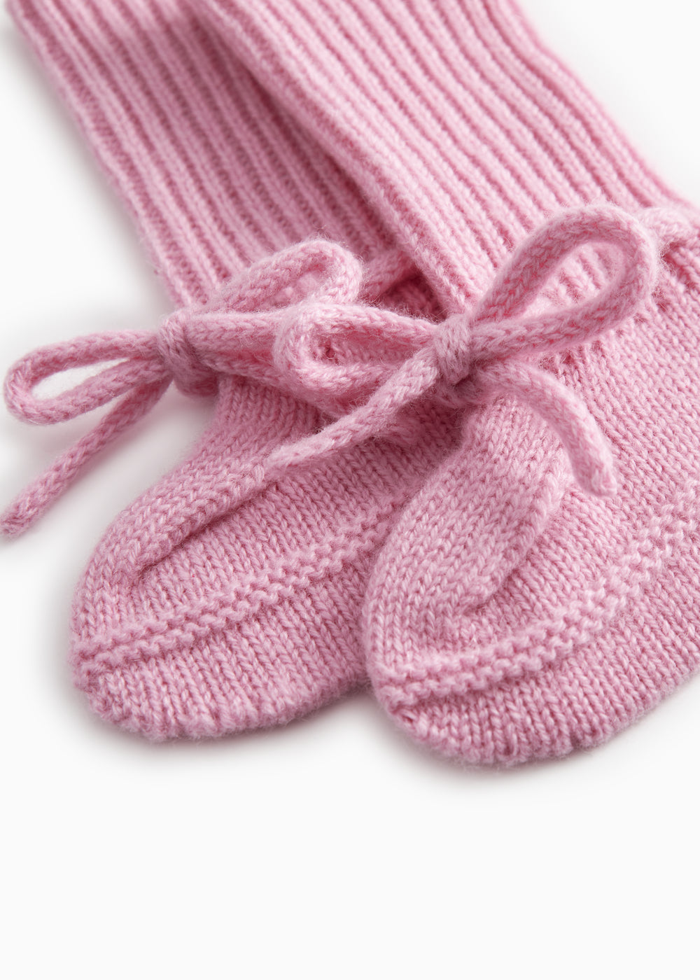 Details of pink knitted baby clothes with a bow front band.