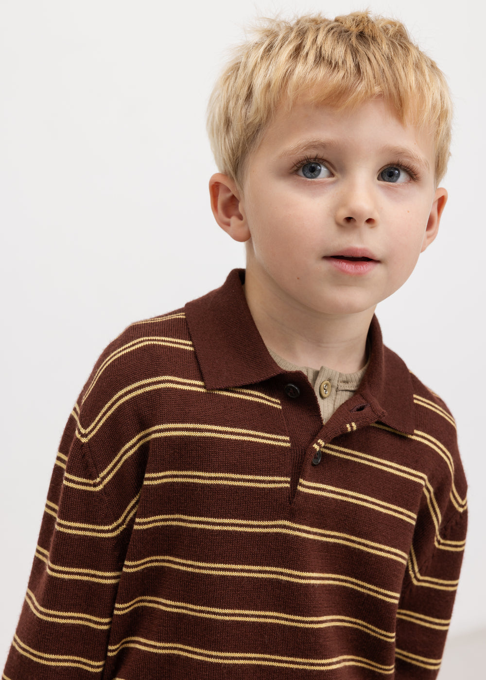 Kids in brown striped polo shirt with short sleeves and button details.