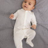 White baby romper with a blue picot collar edge and full-length legs to the feet.