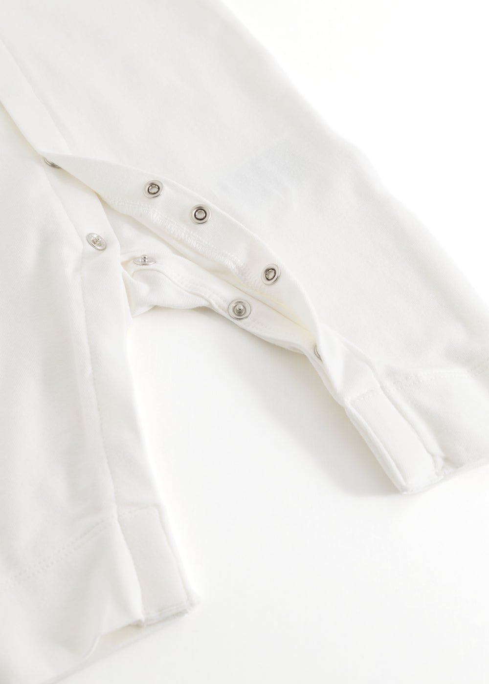 Ricci dress in light off-white with snap button closure and lace trim at the front.