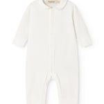 Ricci held a light off-white dress with long sleeves and a front button closure.