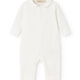 Ricci held a light off-white dress with long sleeves and a front button closure.