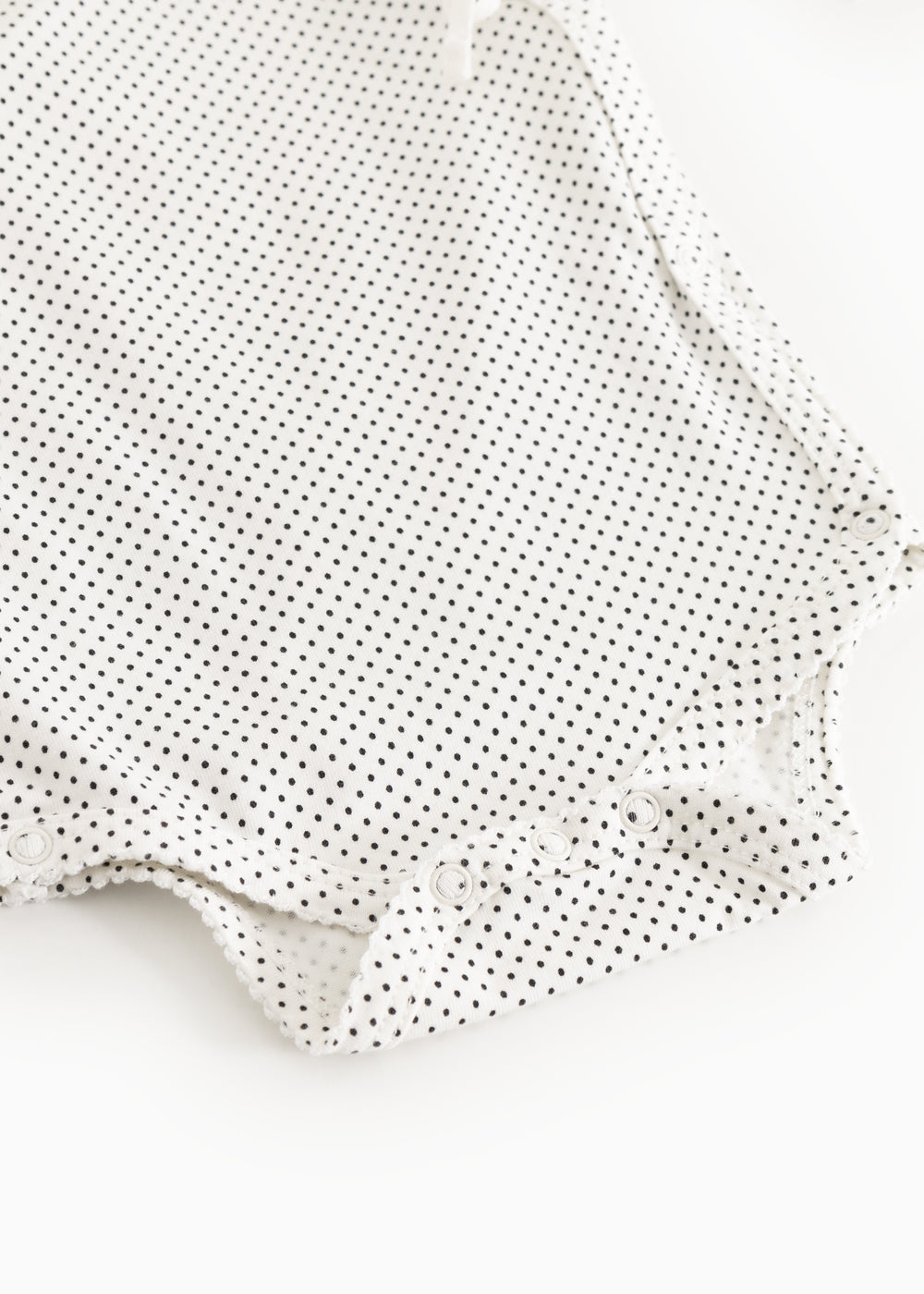 White bodystocking with small black dots and snap buttons.