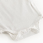 White bodystocking with small black dots and snap buttons.