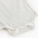 White bodystocking with small black dots and snap buttons.