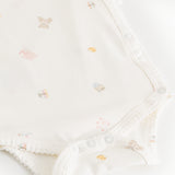 Bodystocking offwhite with a small pattern, creased edge and pressure buttons in steps.
