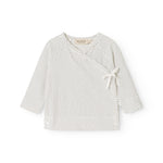 White blouse for baby with small black dots, round collar and front tie.