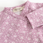 Rubetta dress in pink with small white‑rose floral print and a criss‑cross collar with a label.