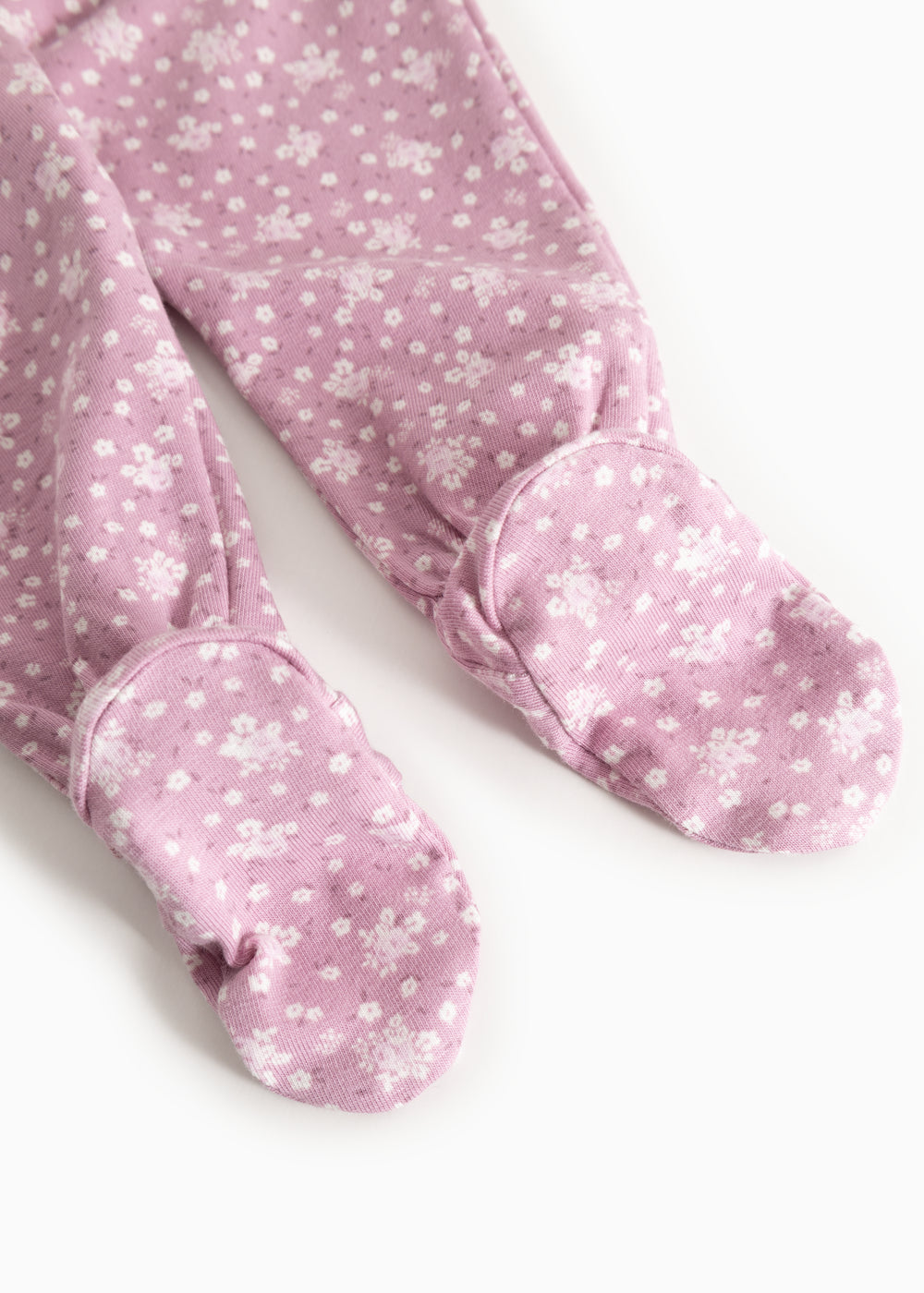 Rubetta dress in pink with small white-pink floral print and feet with fabric cover.