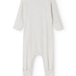 White dress with small black dots, long sleeves and a slit.