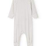 White dress with small black dots, long sleeves and a slit.