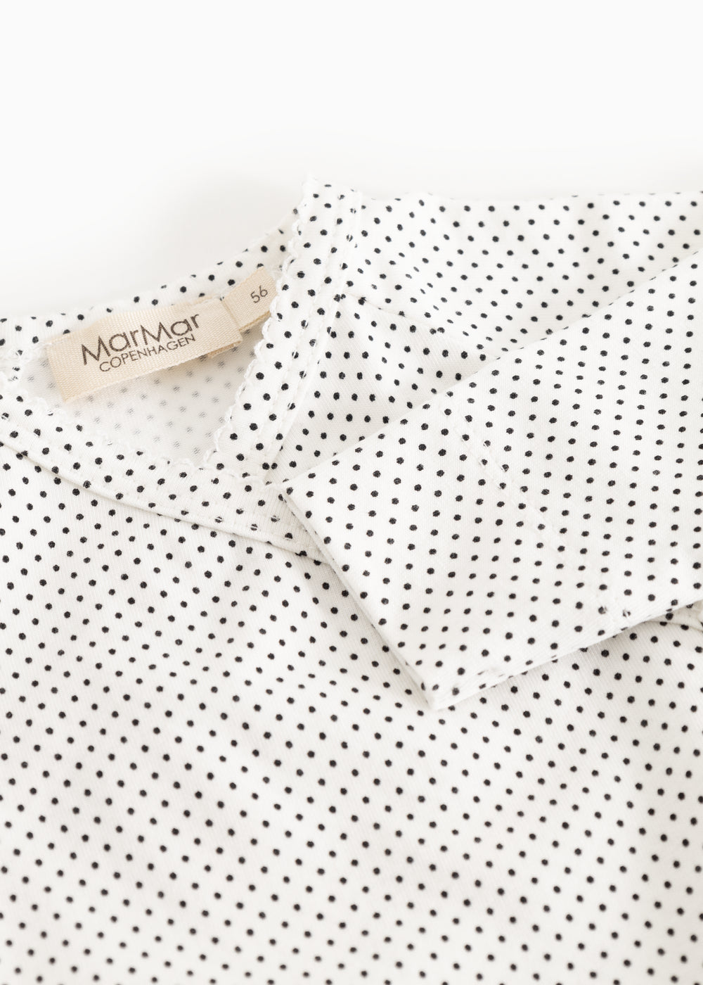 White dress with small black dots, collar with label.