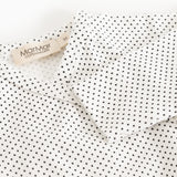 White dress with small black dots, collar with label.