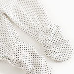 White dress with small black dots, long legs with patterned feet
