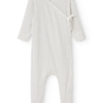 White dress with small black dots and a wrap top at the neck.