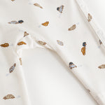 White dress with colored car print and printed button at shoulder.