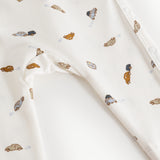 White dress with colored car print and printed button at shoulder.