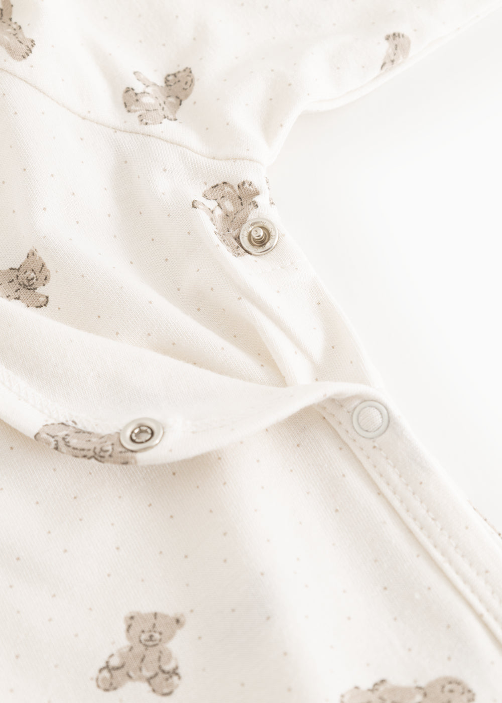 White dress with teddy pattern and snap buttons on the legs