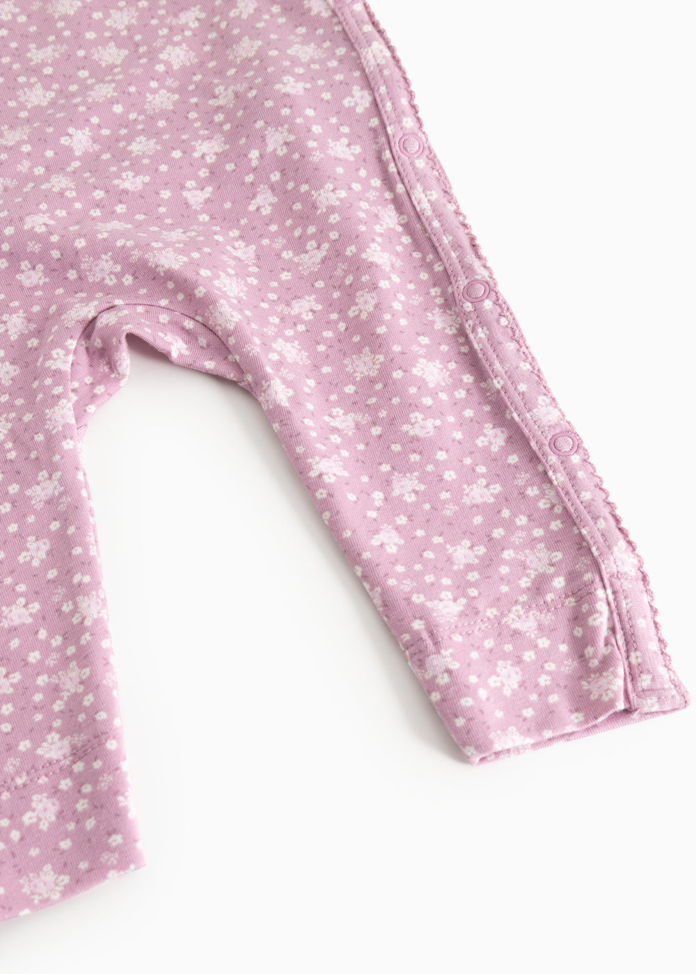 Dress from Rula in pink with small white flowers, long sleeves and a button closure at the neckline.