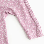 Dress from Rula in pink with small white flowers, long sleeves and a button closure at the neckline.