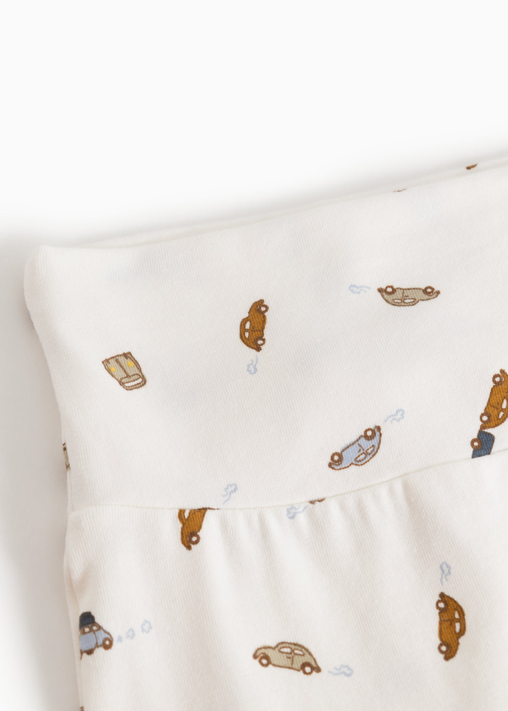 White baby pants with car pattern and soft elastic at the waist.
