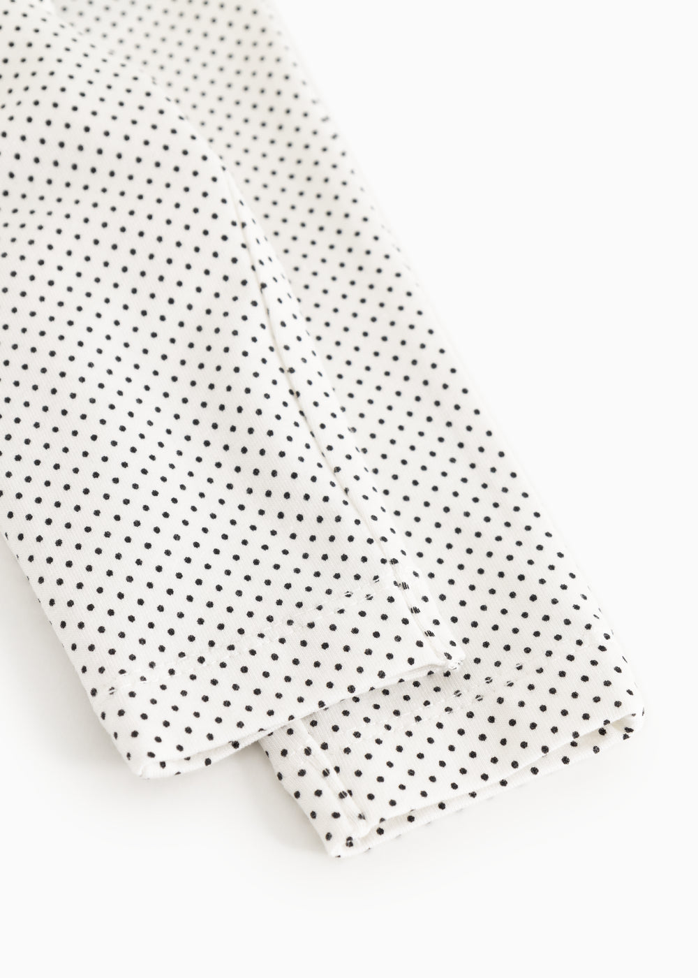 Baby pants with small black dots, close-up of leg ending.