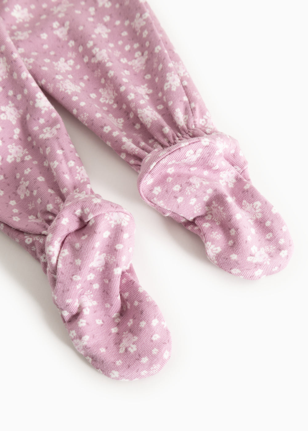 Pink trousers with small white flower print and cuffs at the ankles.