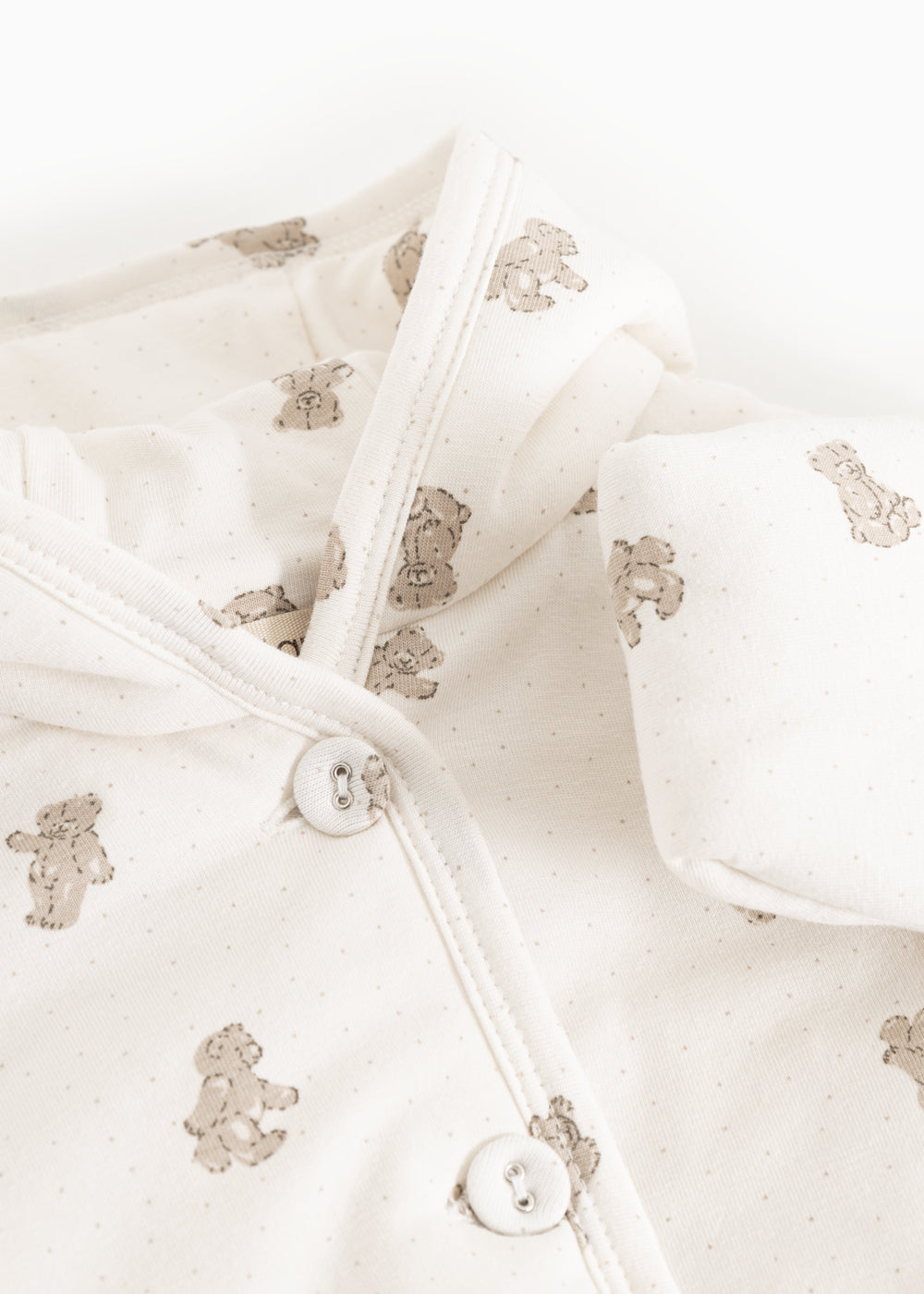 Christmas jacket in cream with a ribbed hem, teddy bear print, and front button closure.