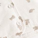 Hooded winter jacket, cream side with teddy bear print and snap buttons.